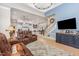 Open concept living room featuring a staircase, large windows, and seamless access to the kitchen at 12500 Richmond Run Dr, Raleigh, NC 27614