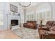 Beautiful living room with fireplace, neutral rug, leather seating, and arched windows at 12500 Richmond Run Dr, Raleigh, NC 27614