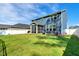 Large grassy backyard featuring a screened porch, white vinyl fence, and other greenery at 128 Potomac River St, Garner, NC 27529