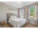 Bright bedroom showcasing two windows with sheer curtains and a comfortable bed and decor at 128 Potomac River St, Garner, NC 27529