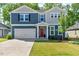 Charming two-story home with a well-manicured lawn, attached garage and inviting red front door at 128 Potomac River St, Garner, NC 27529