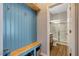 Hallway with blue wainscoting, wooden shelves and bench, and bathroom with glass shower at 128 Potomac River St, Garner, NC 27529