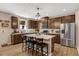 Kitchen boasts quartz countertops, dark wood cabinets, a stainless steel refrigerator, and a kitchen island at 128 Potomac River St, Garner, NC 27529