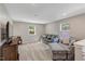 Inviting living room with gray sofa, plush carpeting, and natural light creating a warm and comfortable space at 128 Potomac River St, Garner, NC 27529