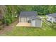 Aerial view of the backyard featuring a deck, cozy building extension, and well-maintained grass at 128 W Parker St, Henderson, NC 27536