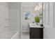 Bathroom featuring double vanity, tub and shower combo, and neutral color palette at 128 W Parker St, Henderson, NC 27536
