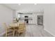 Bright kitchen with stainless steel appliances, white cabinetry, and a cozy dining area at 128 W Parker St, Henderson, NC 27536