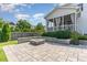 Backyard featuring custom paver patio with fire pit, lush greenery, and access to the screened porch at 1304 Revolution Cir, Raleigh, NC 27603
