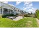 Spacious backyard featuring a stone patio, fire pit, screened porch, and lush lawn area at 1304 Revolution Cir, Raleigh, NC 27603