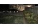Night view of home's exterior with fire pit, lighting, and paver patio surrounded by green grass at 1304 Revolution Cir, Raleigh, NC 27603