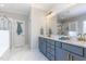 Bathroom featuring double sinks with a marble counter, grey cabinets and a glass enclosed shower at 1304 Revolution Cir, Raleigh, NC 27603