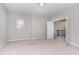 A spacious bedroom with neutral carpet and an open doorway to a staircase at 1304 Revolution Cir, Raleigh, NC 27603