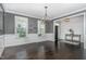 Formal dining room featuring wainscoting, chandelier, and large windows offering ample natural light at 1304 Revolution Cir, Raleigh, NC 27603