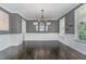 Formal dining room with wainscoting, chandelier, and gray walls for a cozy and sophisticated feel at 1304 Revolution Cir, Raleigh, NC 27603