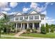Inviting two-story home featuring a covered front porch and manicured lawn at 1304 Revolution Cir, Raleigh, NC 27603