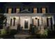 Two-story home at night featuring a covered porch with hanging plants and stone accents at 1304 Revolution Cir, Raleigh, NC 27603
