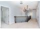 Hallway with carpeted floor and decorative chandeliers that lead to the staircase at 1304 Revolution Cir, Raleigh, NC 27603