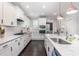 Beautiful kitchen with white cabinetry, marble countertops, stainless steel appliances, and modern pendant lighting at 1304 Revolution Cir, Raleigh, NC 27603