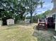 Expansive backyard with a storage shed, swing, mature trees, and a wood deck at 1305 Shakentown St, Knightdale, NC 27545