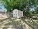 Exterior view of a yard shed with light siding and an X design on the door, surrounded by a wood fence at 1305 Shakentown St, Knightdale, NC 27545