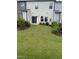 Private backyard with a manicured lawn and neatly trimmed shrubs, accessible through sliding glass doors at 136 Ashlar Ct, Cary, NC 27519