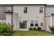 Backyard with a sliding glass door, a small area of grass, and a row of bushes along the back of the home at 136 Ashlar Ct, Cary, NC 27519