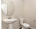 Chic powder room features a pedestal sink with modern fixtures, paired with a sleek toilet, creating a stylish and functional space at 136 Ashlar Ct, Cary, NC 27519