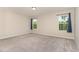Empty bedroom with neutral carpet, two large windows, and light gray walls at 136 Ashlar Ct, Cary, NC 27519