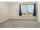 Bright bedroom featuring plush carpeting, neutral walls, and a pair of windows providing natural light and neighborhood views at 136 Ashlar Ct, Cary, NC 27519