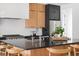 Kitchen featuring a large island with a black countertop and wooden chairs, complemented by stainless steel appliances at 1405 Watts St, Durham, NC 27701