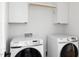 Well-equipped laundry room featuring modern Samsung washer and dryer set with white cabinets and light wood rod at 1405 Watts St, Durham, NC 27701