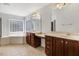 Bright bathroom features a separate tub and vanities with wooden cabinets and tile flooring at 1420 Lagerfeld Way, Wake Forest, NC 27587