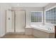 Bright bathroom features a separate tub and shower area with a glass block window at 1420 Lagerfeld Way, Wake Forest, NC 27587