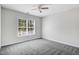A well-lit bedroom featuring neutral walls and carpet, and a large window at 1420 Lagerfeld Way, Wake Forest, NC 27587