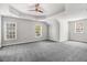 Spacious bedroom features a tray ceiling, neutral paint, carpeted floor, and plenty of natural light at 1420 Lagerfeld Way, Wake Forest, NC 27587
