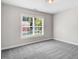 A well-lit bedroom featuring neutral walls and carpet, and a large window at 1420 Lagerfeld Way, Wake Forest, NC 27587