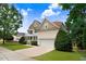 View of the side of a charming two-story home with beautiful landscaping and an attached two-car garage at 1420 Lagerfeld Way, Wake Forest, NC 27587