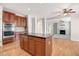Bright kitchen area with wooden cabinets, granite countertops, and a view of a cozy living room at 1420 Lagerfeld Way, Wake Forest, NC 27587