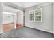 Bright living room features neutral paint, gray carpet, and large window at 1420 Lagerfeld Way, Wake Forest, NC 27587