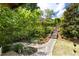 Landscaped backyard featuring stone walkway, garden, wood stairway, and lush greenery leading to upper level at 1503 Hollywood St, Durham, NC 27701