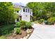 Two-story home featuring an expansive driveway, lush landscaping, and a charming fire pit area at 1503 Hollywood St, Durham, NC 27701