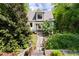 Quaint home with a stone pathway leading to the front door, surrounded by lush greenery and trees at 1503 Hollywood St, Durham, NC 27701