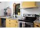 A well-lit kitchen showcases granite counters, stainless steel appliances, and stylish yellow cabinetry at 1503 Hollywood St, Durham, NC 27701