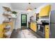 Bright kitchen featuring stainless steel appliances, yellow cabinets, and hardwood floors at 1503 Hollywood St, Durham, NC 27701