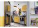 Charming kitchen with yellow cabinets, stainless appliances, and modern lighting fixtures at 1503 Hollywood St, Durham, NC 27701