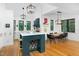 Bright kitchen with white cabinets, a contrasting emerald island, and a dining area with hardwood floors at 1503 Hollywood St, Durham, NC 27701
