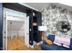 Living room featuring an accent wall with playful wallpaper, blue couch and built in shelving at 1503 Hollywood St, Durham, NC 27701