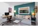 Living room area including gray sofa, office desk, and large decorative window at 1503 Hollywood St, Durham, NC 27701