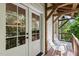 Covered porch featuring white chairs and framed glass doors leading inside at 1503 Hollywood St, Durham, NC 27701