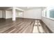 Well-lit living room with gray wood floors, recessed lights, and three windows at 171 Piney Field Rd, Fuquay Varina, NC 27526